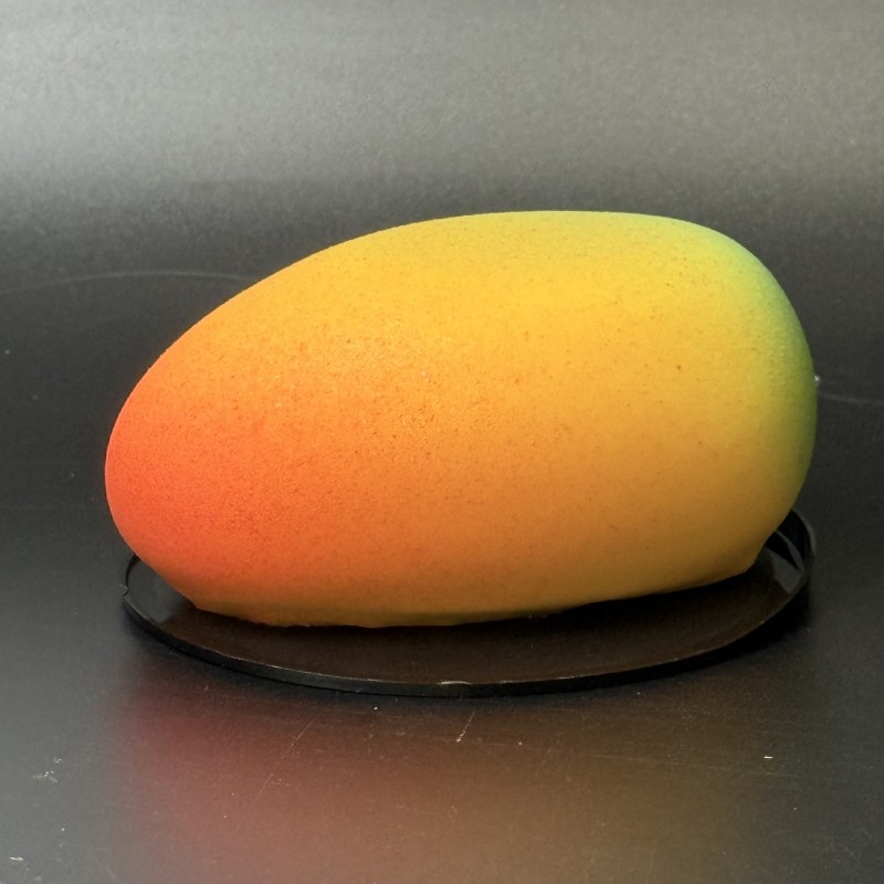 Mango-shaped mousse dessert with mango purée, passion fruit mousse, and chocolate shell