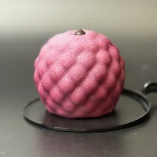 Berry-shaped mousse dessert with black currant filling and chocolate shell