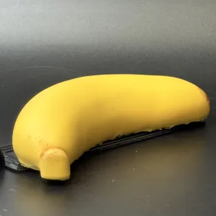 Banana-shaped dessert with banana purée, chocolate mousse, and chocolate shell