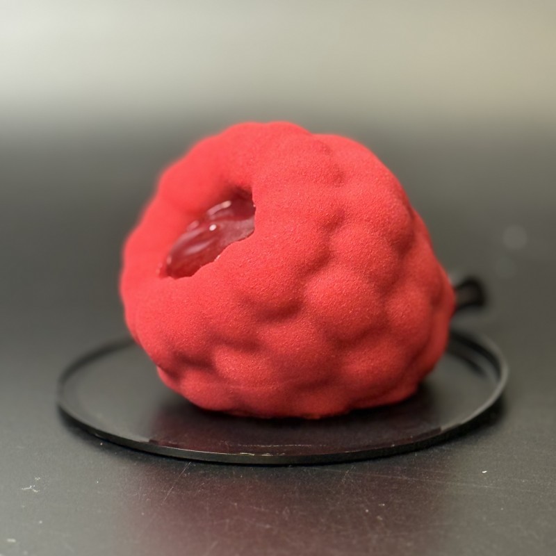Fruit-shaped pistachio lime raspberry mousse dessert with raspberry filling and chocolate shell