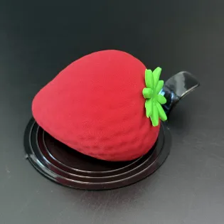 Strawberry-shaped mousse dessert with strawberry jam and chocolate shell